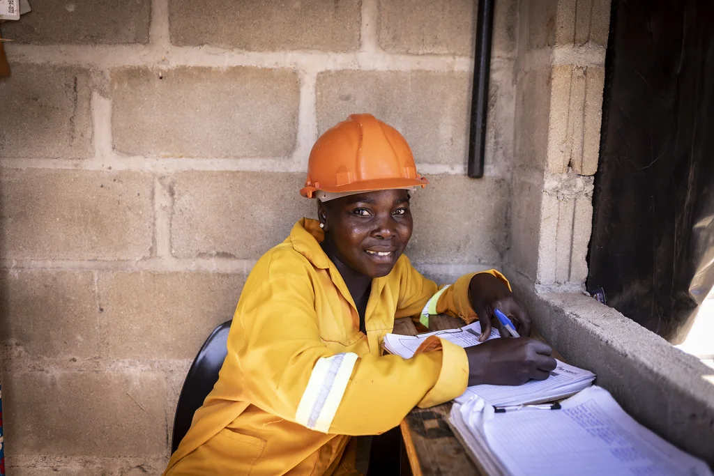 Technicienne en casque orange travaillant sur des documents de chantier