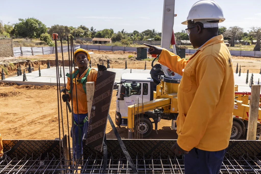 Chef de chantier donnant des consignes devant une pompe à béton